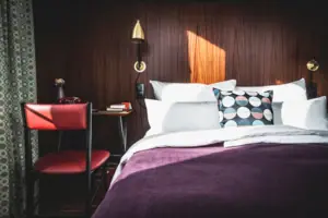 Ein Bett mit Kissen und einem Schreibtisch in einem Zimmer.