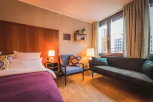 Das L-Studio Hotelzimmer im HENRI Hotel Düsseldorf mit einem Bett und einem Sofa.