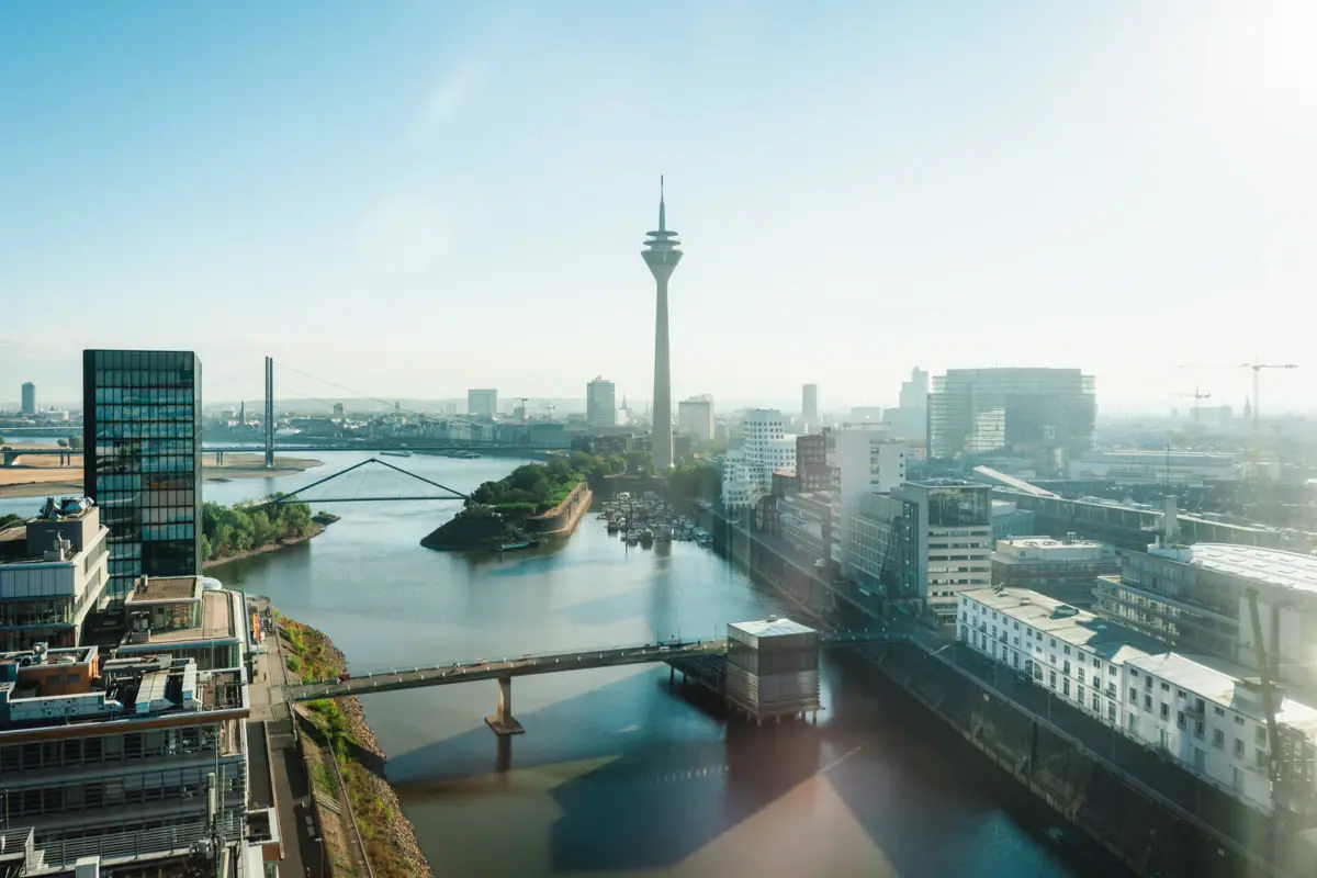 Eine Stadtansicht mit einem Fluss, einer Brücke und einem Turm.