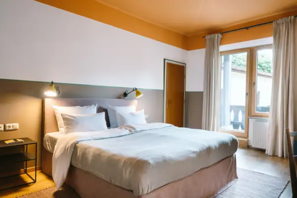 Hotelzimmer im HENRI Hotel Garmisch-Partenkirchen Ein Bett in einem Hotelzimmer im HENRI Hotel Garmisch-Partenkirchen mit stilvollem Interieur.