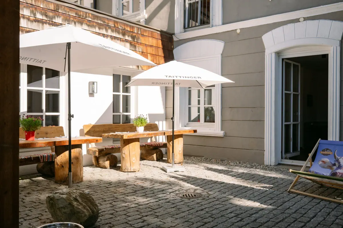 Ein Patio mit Sonnenschirmen und Tischen.