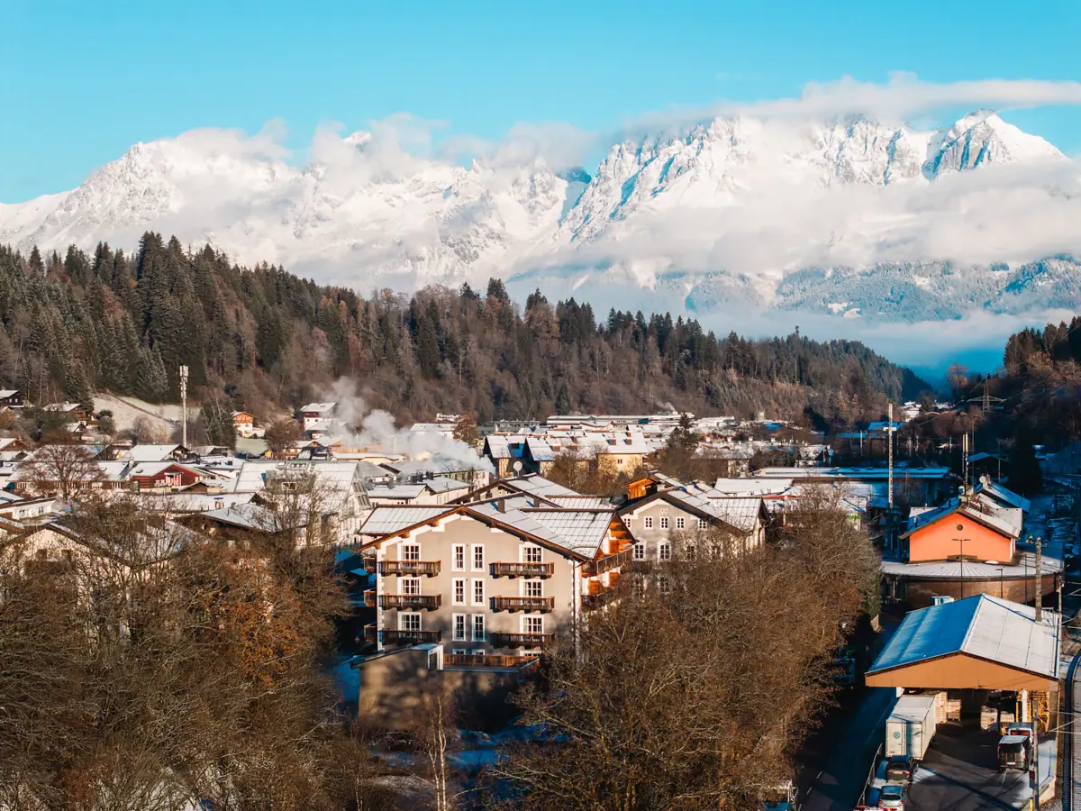 Ein Bergdorf mit schneebedeckten Bergen im Hintergrund.