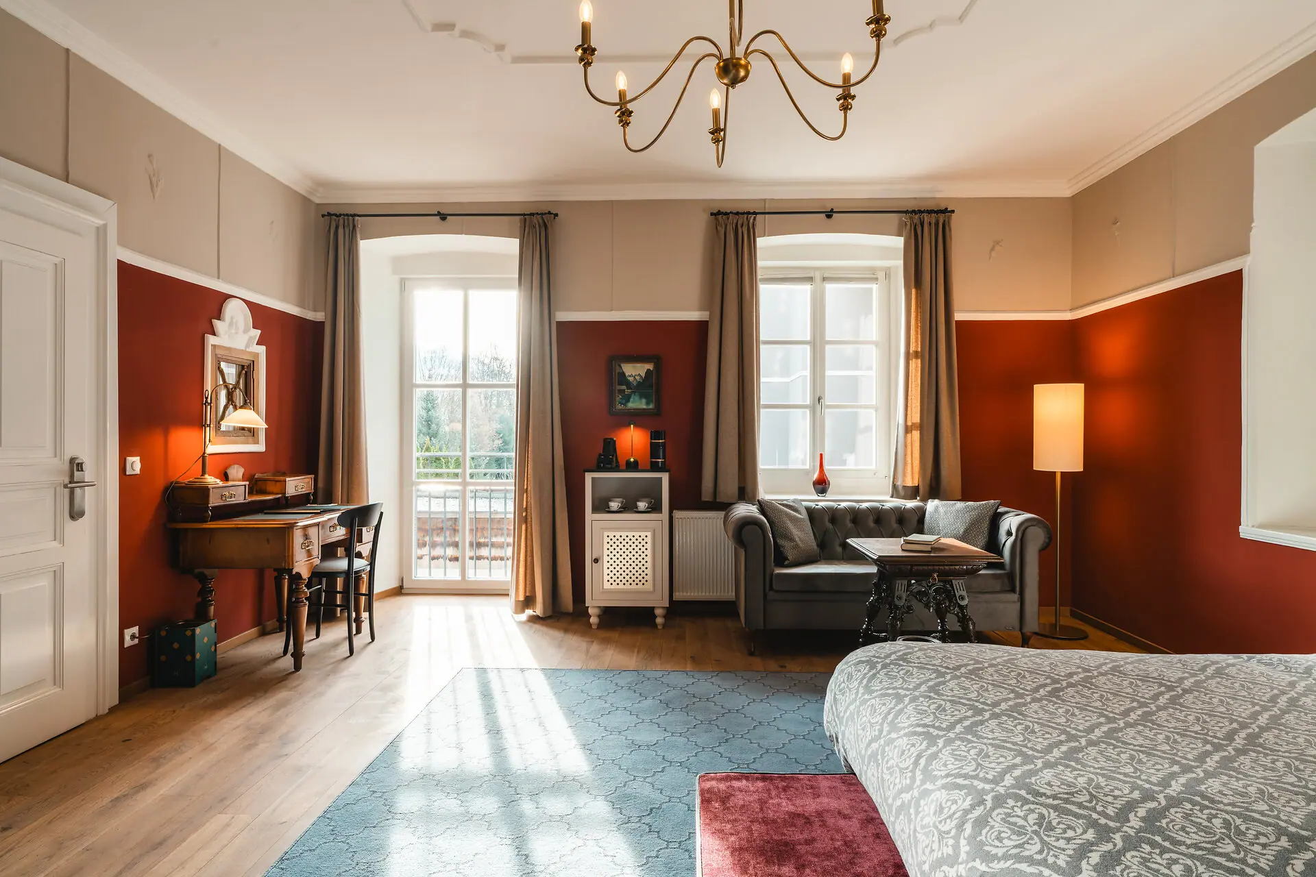 HENRI Kitzbühel Hotelzimmer Ein Zimmer mit einem Sofa und einem Schreibtisch.