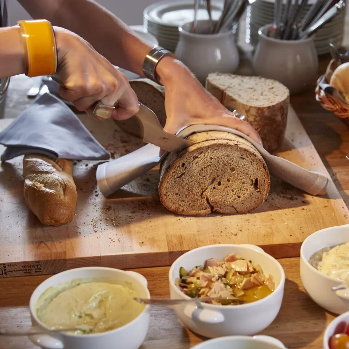 Eine Person schneidet ein Laib Brot.