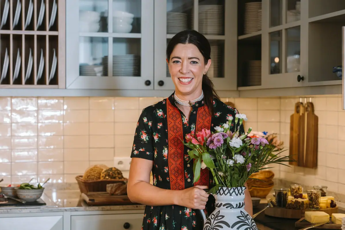 Eine Frau hält eine Vase mit Blumen.