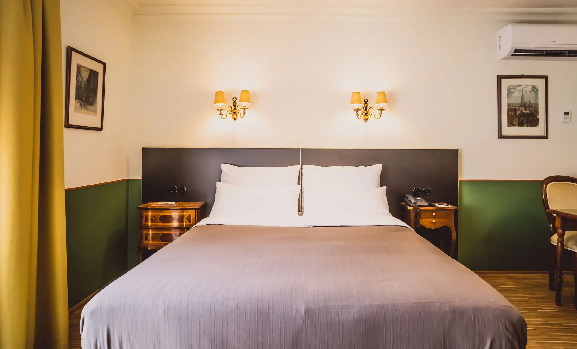 Zimmer Bett mit zwei Wandlampen in einem stilvollen Hotelzimmer.