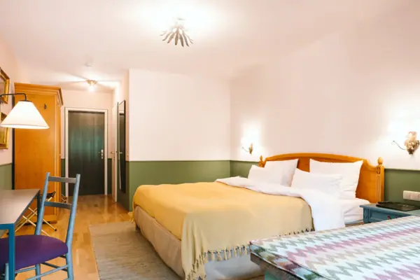 Hotelzimmer HENRI Hotel Garmisch-Partenkirchen Ein Hotelzimmer im HENRI Hotel Garmisch-Partenkirchen mit einem Bett und einem Tisch.