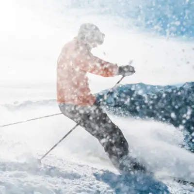 Eine Person fährt auf Skiern einen Hang hinunter.