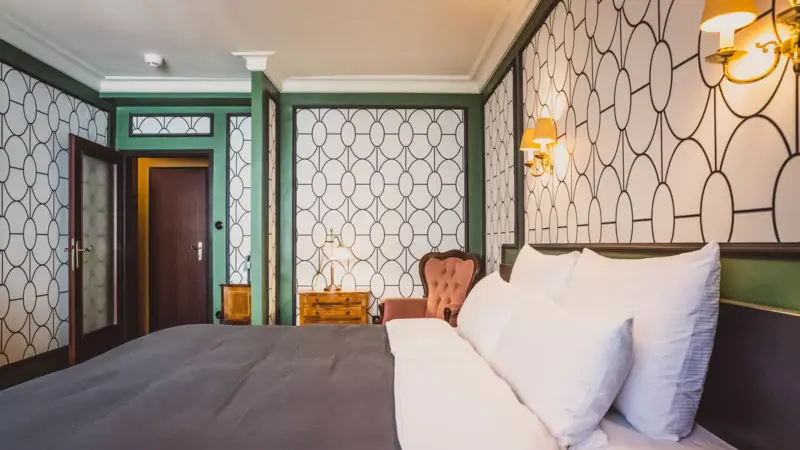 Ein Bett mit Kissen und einem Stuhl in einem Zimmer.