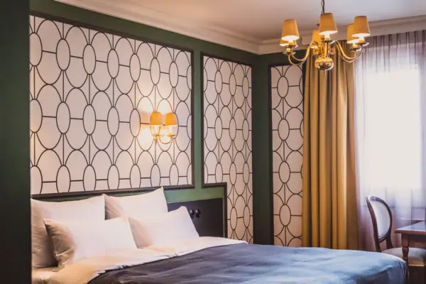 Ein Bett mit einem Kronleuchter und Vorhängen.