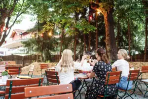 Eine Gruppe von Menschen sitzt an Tischen im Freien.