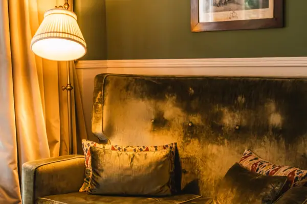 Ein Sofa mit Kissen und einer Lampe in einem Raum.