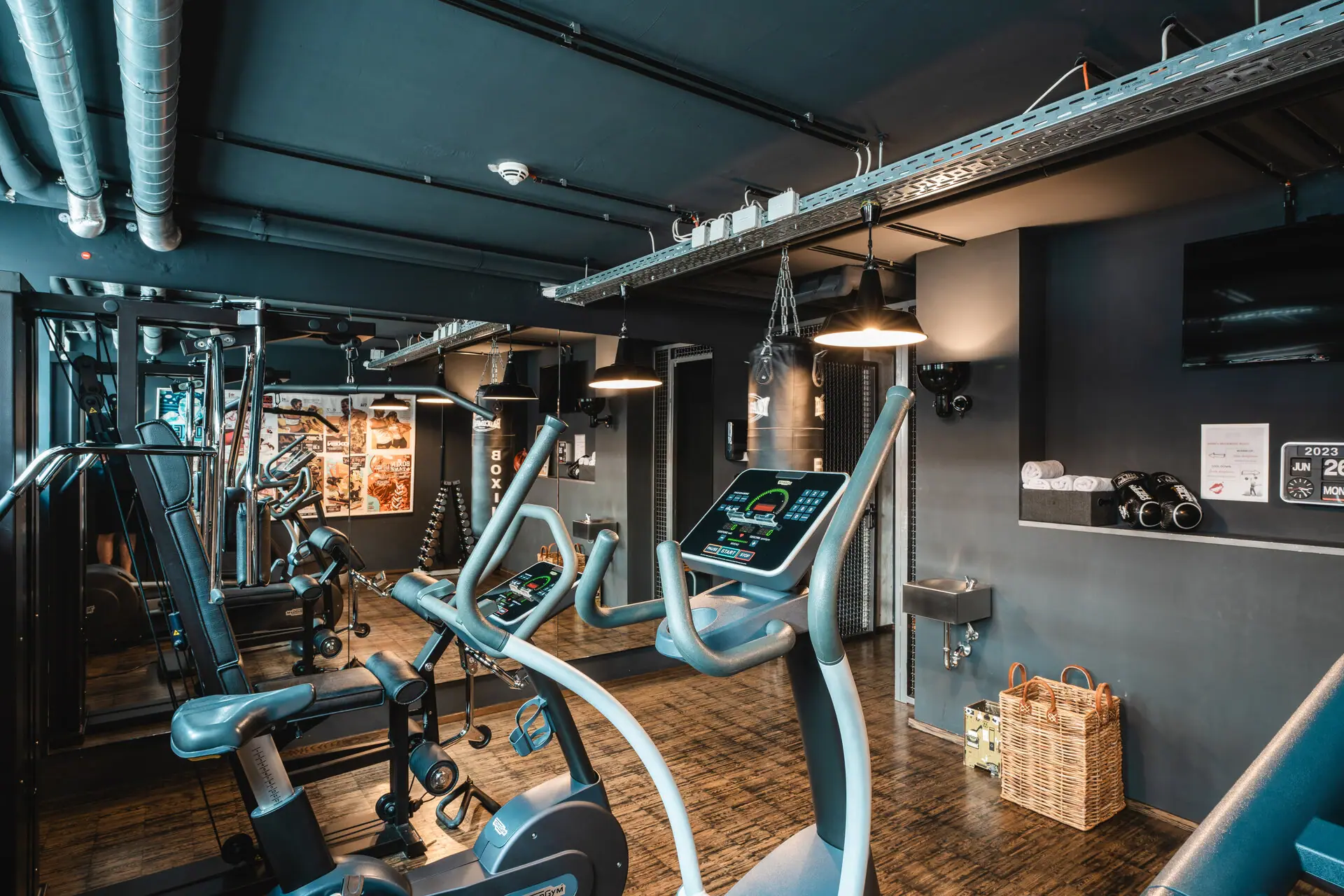 Ein Raum mit Fitnessgeräten und Holzboden.