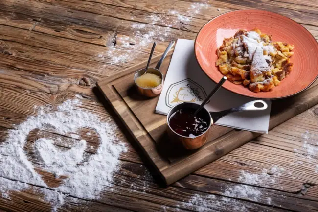 Rosi's Sonnbergstuben Ein Teller mit Essen auf einem Holzbrett.