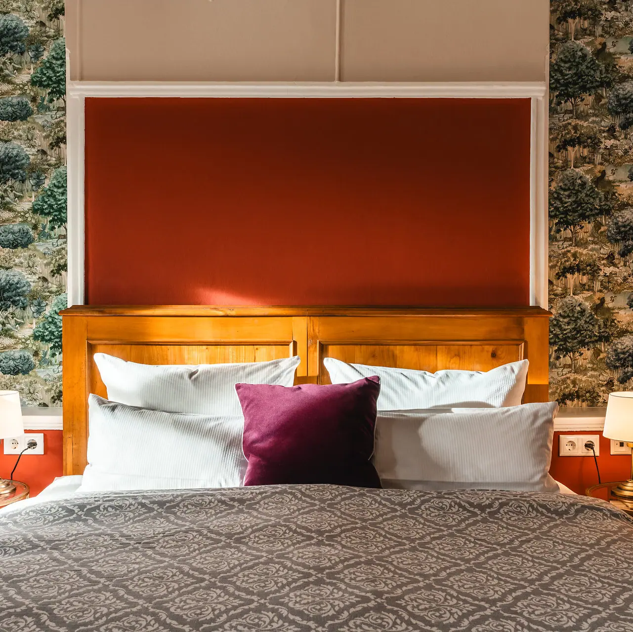 Ein Bett mit einem rot-weißen Kissen.