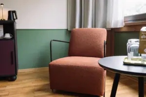 Stzbereich im HENRI Garmisch-Partenkirchen Ein Sessel in einem Raum.