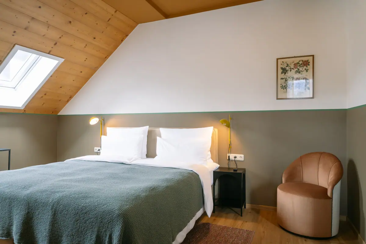 Bett in einem stilvoll eingerichteten Zimmer mit Kissen und Bettwäsche.