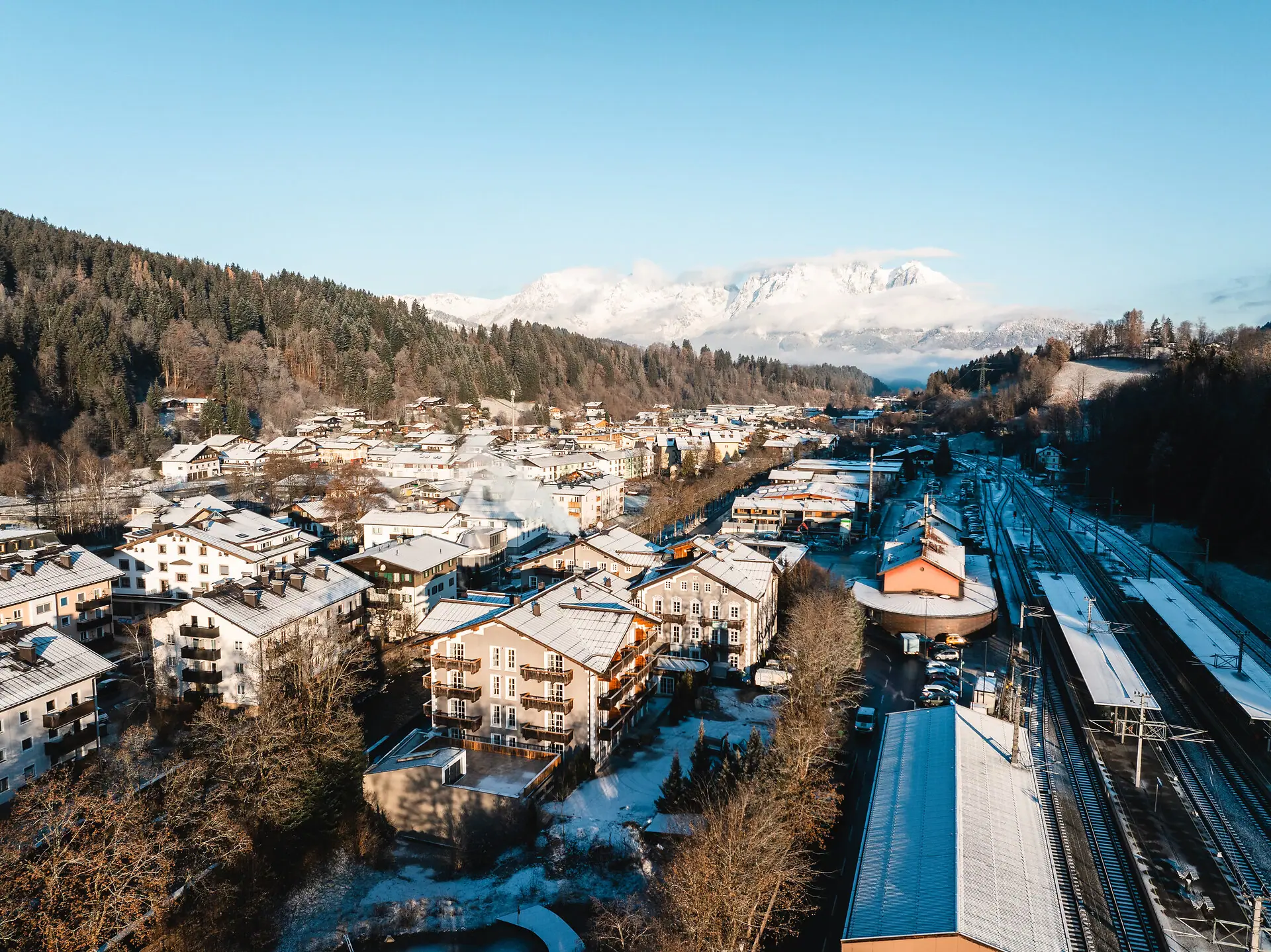 Eine verschneite Stadt im Winter mit Bergen im Hintergrund.