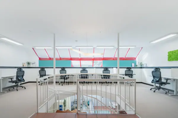 Ein weißer Raum mit Treppe und Stühlen.