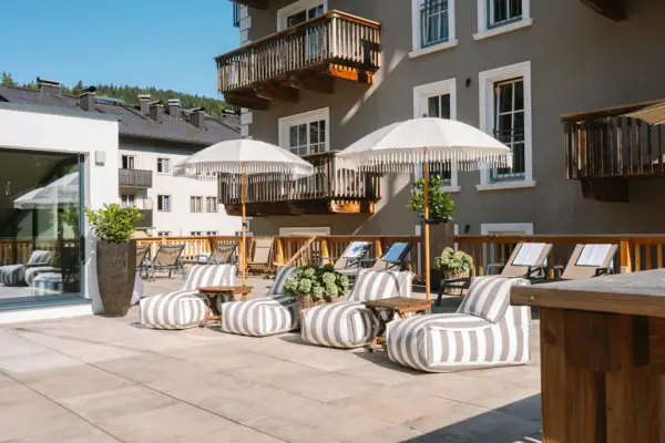 HENRI Spa Ein Patio mit Stühlen und Sonnenschirmen.