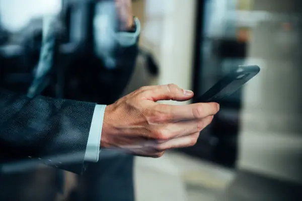 Eine Hand hält ein Mobiltelefon.