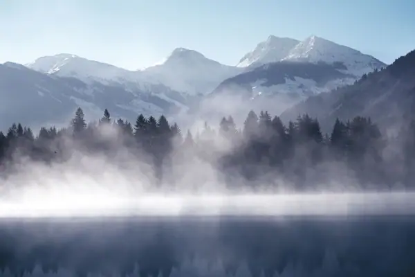 Kitzbühel Schwarzsee Nebeliger See mit Bergen im Hintergrund
