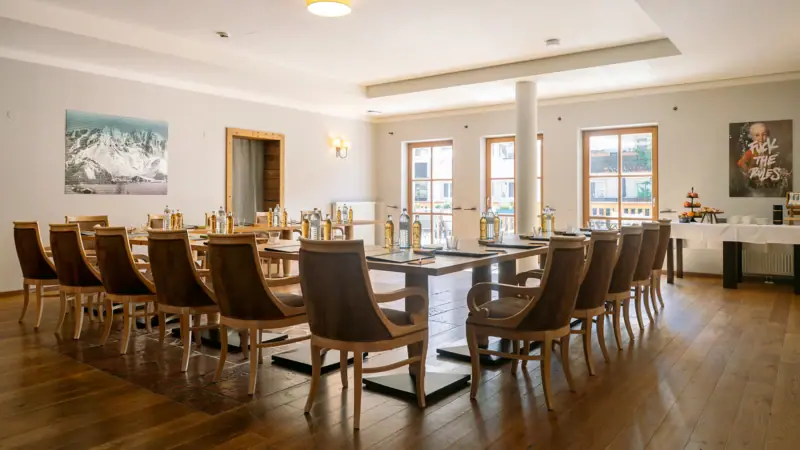 Ein Tagungsraum im HENRI Hotel Kitzbühel mit Tischen und Stühlen.