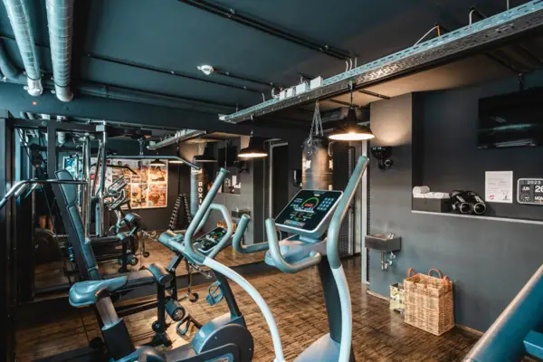 Ein Raum mit Fitnessgeräten und Holzboden.