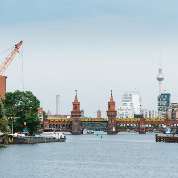 Brücke über einen Fluss mit Kran und Stadt im Hintergrund.