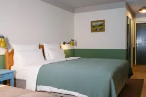 Bettbereich im Salon Bett mit grünem Überwurf und Lampe im Schlafzimmer.