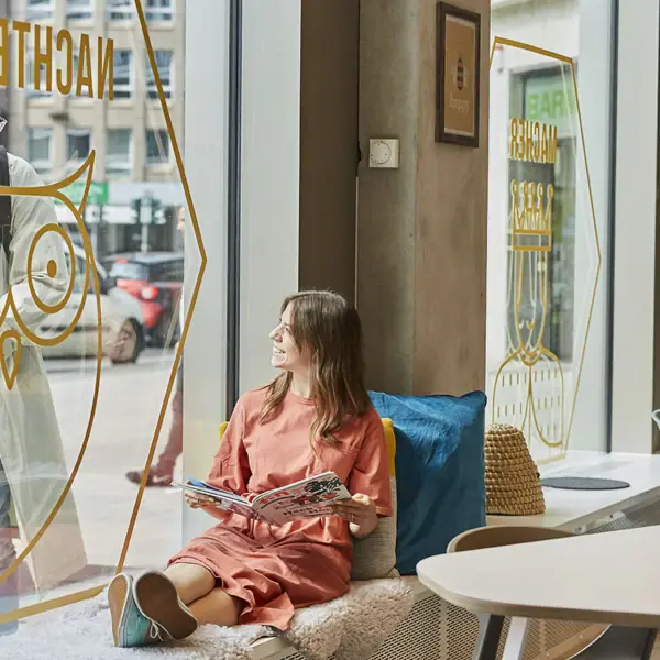 Eine Frau sitzt auf einer Fensterbank.