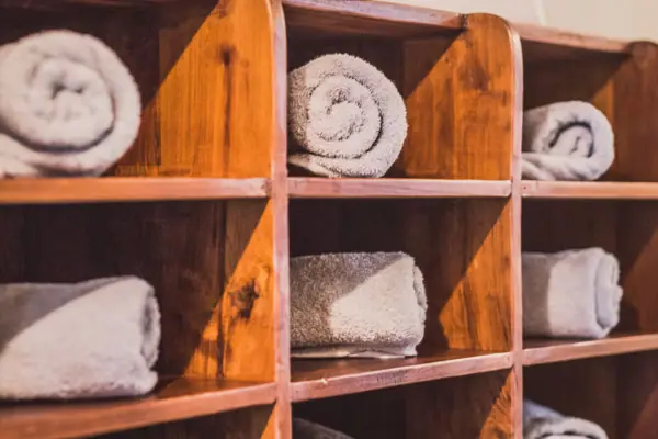 Holzregal mit gerollten weißen Handtüchern