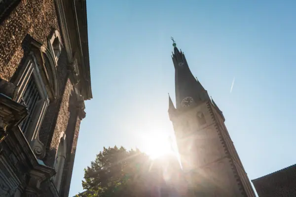 Basilika St. Lambertus Düsseldorf Ein Gebäude mit Uhrturm vor klarem Himmel.