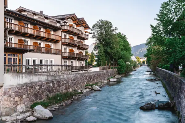 Fluss mit einem Gebäude und Bäumen im Vordergrund