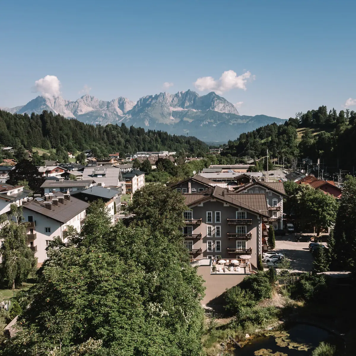 Kitzbühel von oben mit Bäumen und Bergen im Hintergrund.