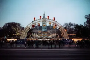 Christkindlmarkt Eine Gruppe von Menschen steht vor einem großen Gebäude im Freien.