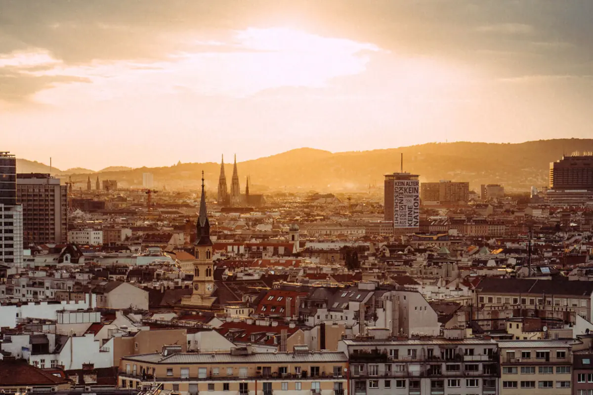 Blick über Wien Stadtansicht von Wien mit vielen Gebäuden und Bäumen unter einem bewölkten Himmel.