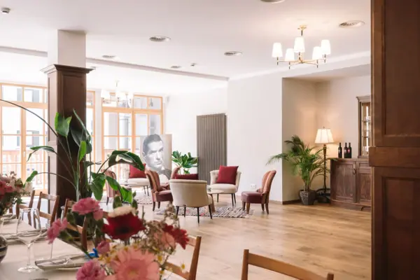 Ein Zimmer mit einem Tisch, Stühlen und einer Vase mit Blumen.