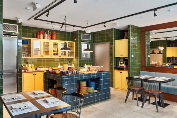 Ein Raum mit grünen Fliesen und gelben Schränken.