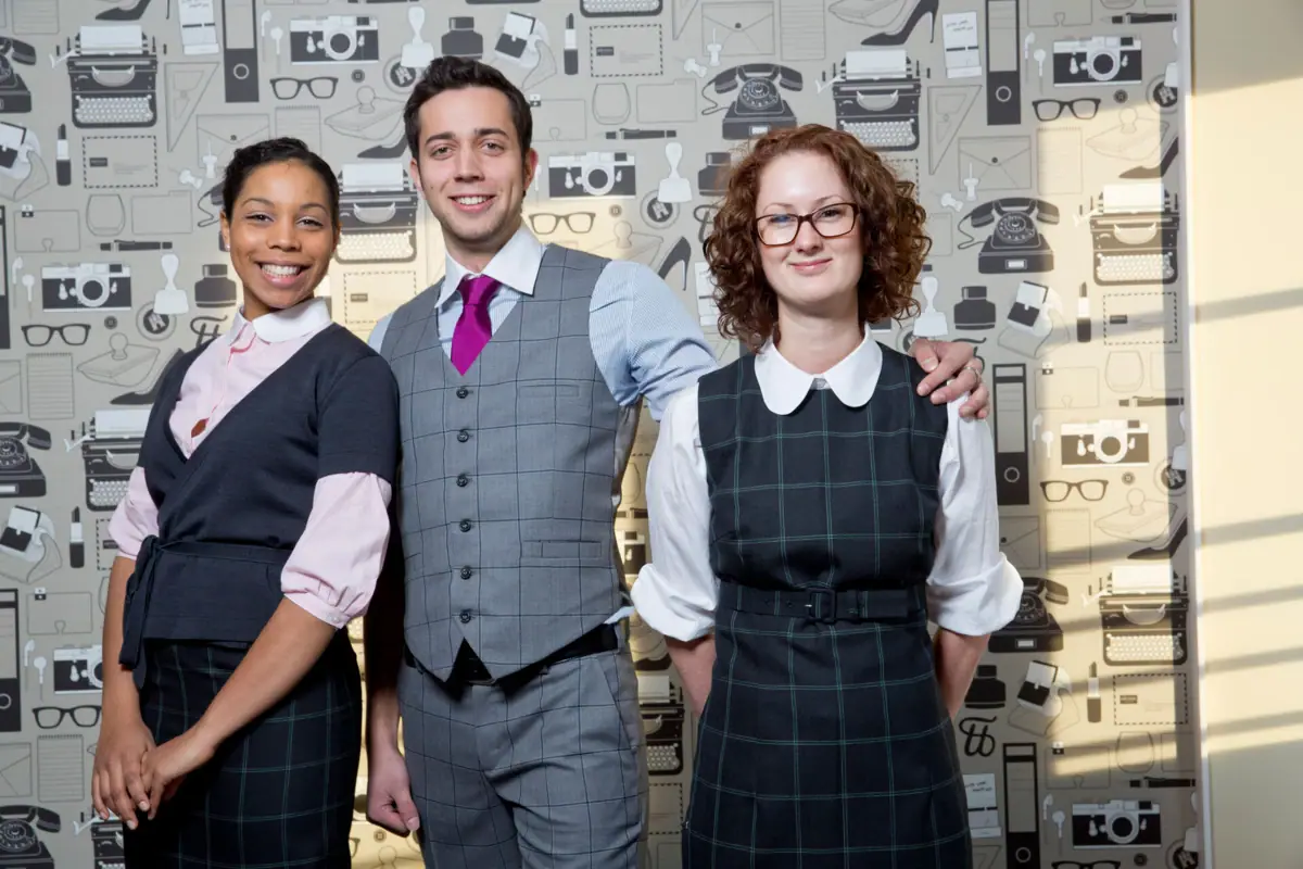 Eine Gruppe von Menschen posiert für ein Foto, lächelnd und in formeller Kleidung.