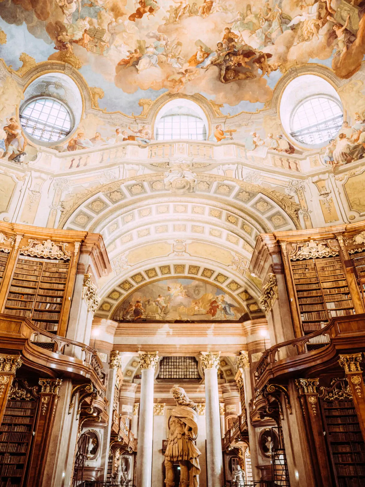 Österreichische Nationalbibliothek Eine große, verzierte Bibliothek mit einem Deckenfresko.
