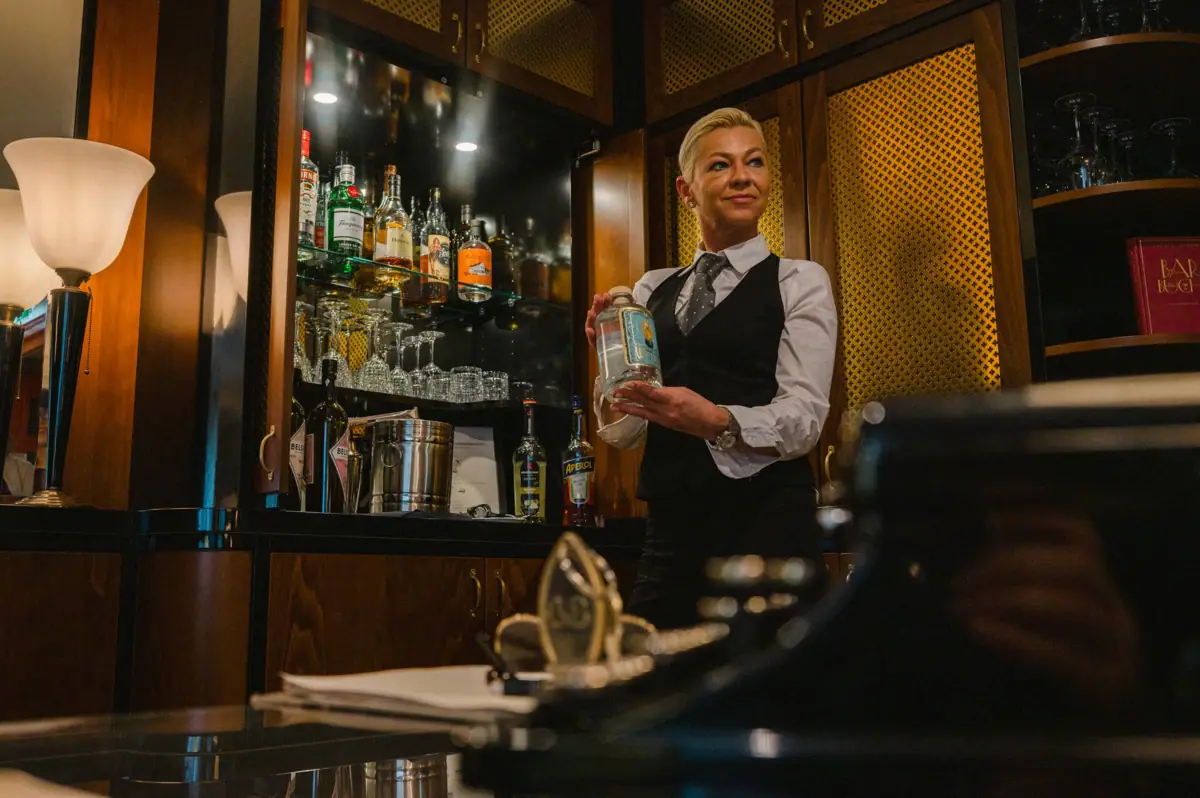 Eine Frau hält eine Flasche Alkohol.