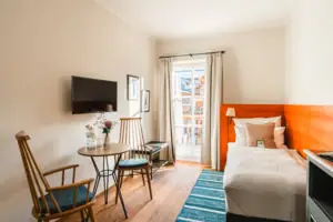 Ein Zimmer mit einem Bett, einem Tisch und Stühlen.