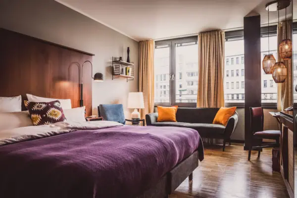 HENRI Düsseldorf Schlafzimmer mit lila Bett und Couch
