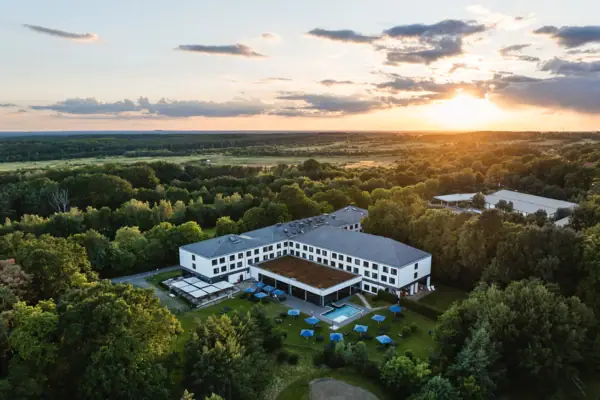 Das aja Hotel in Bad Saarow mit einem Pool, umgeben von Bäumen.