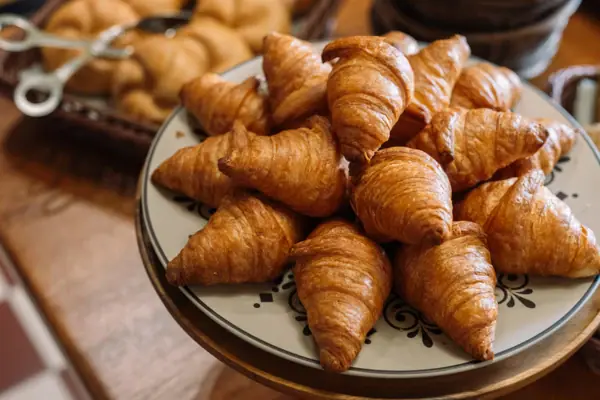 Frühstück im HENRI Garmisch-Partenkirchen Ein Teller mit Croissants auf einem Tisch.