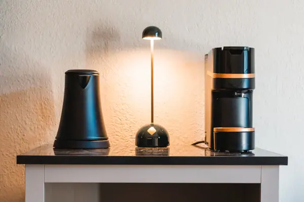 Kaffeemaschine und Tassen auf einem Regal