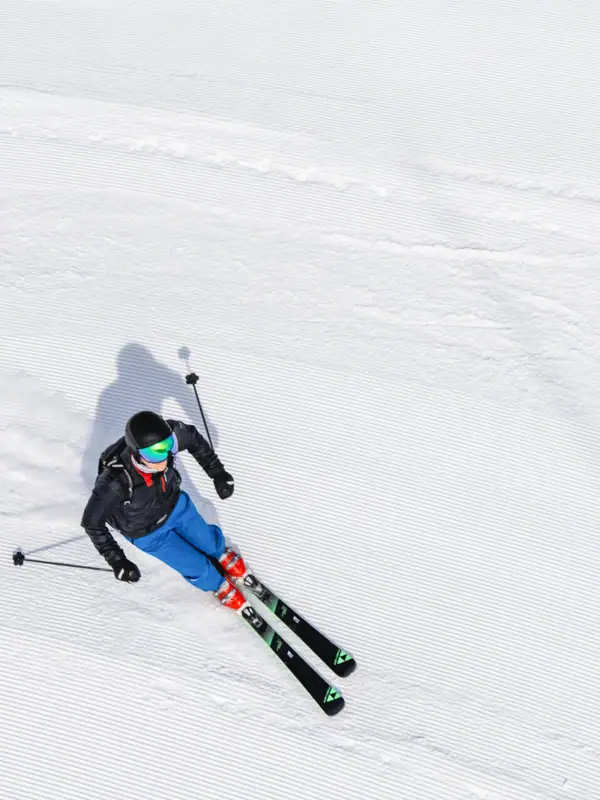Eine Person fährt auf Skiern einen Hang hinunter.