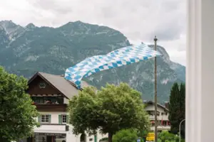 Ausblick im HENRI Garmisch-Partenkirchen Eine Flagge weht über einem Gebäude.