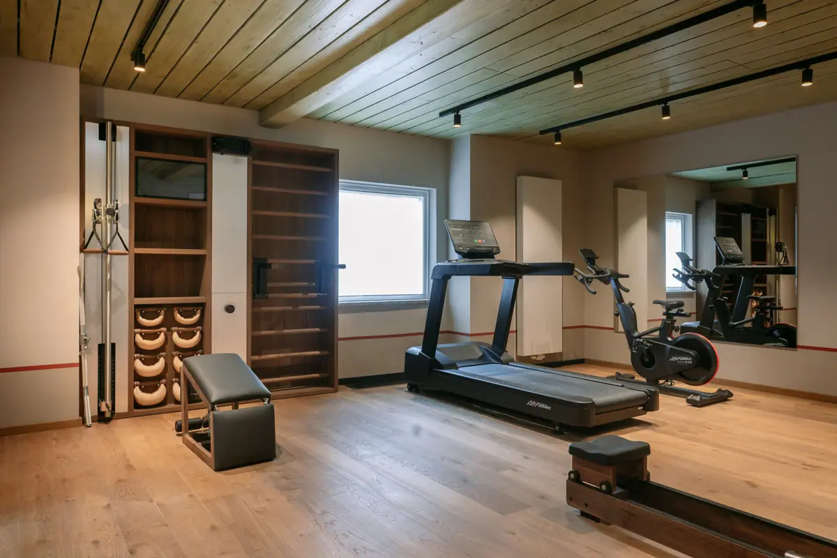 Ein Raum mit Fitnessgeräten und Holzboden.
